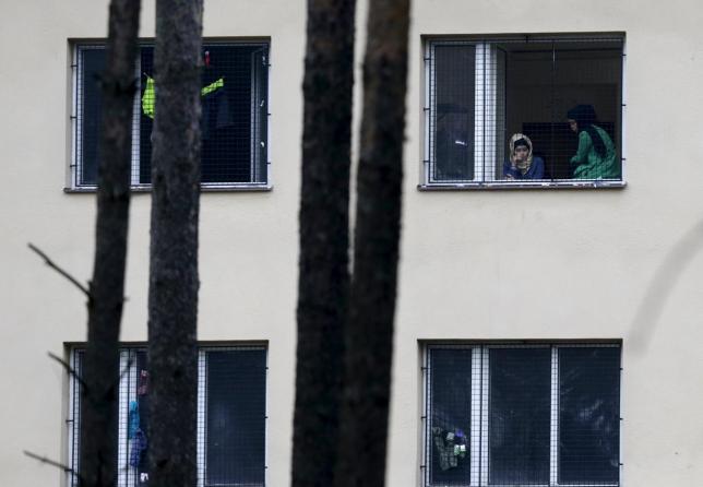 Migrants look out of a window in the Facility For Detention Of Foreigners in Bela-Jezova